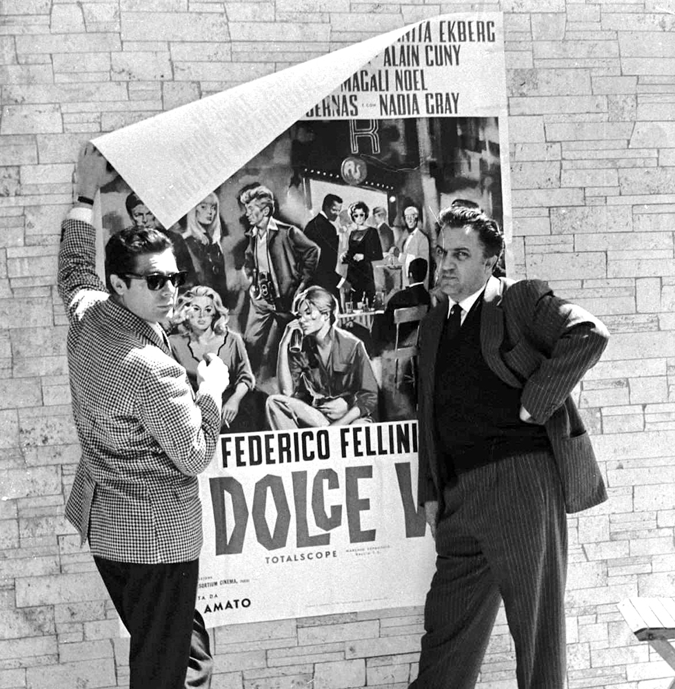 Ο Μαρτσέλο Μαστρογιάνι, ο Φεντερίκο Φελίνι και η αφίσα της ταινίας, από το φακό του Τάτζιο Σεκιαρόλι. 