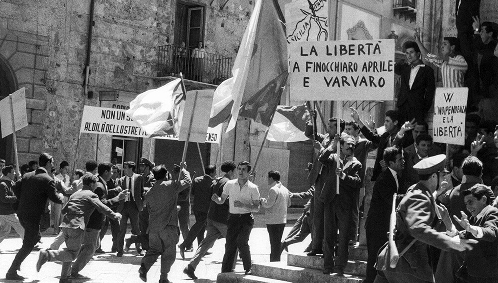 Το ταραγμένο προεκλογικό κλίμα μεταφέρθηκε πιστά στην οθόνη. Εμφανίζεται ακόμα και το σκίτσο-σύμβολο, με το ψαλίδι που αποκόπτει την Σικελία (σε ένα πανό, πάνω δεξιά)… 