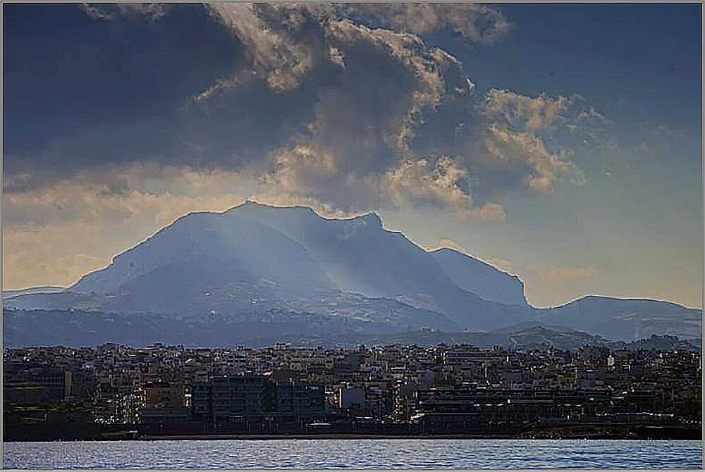 Ο Γιούχτας, το ιερό βουνό της Κρήτης, νότια του Ηρακλείου. Το “πρόσωπο του Δία”.  Συνδεδεμένο, κατά τον Γιάννη Σακελλαράκη, με τελετουργικές ανθρωποθυσίες στην ύστερη Μινωική περίοδο.  (Ένας σεισμός πάγωσε τον χρόνο μιας τέτοιας τελετής, φανερώνοντας το 1979 έναν νέο άνδρα ξαπλωμένο στον βωμό,  με ένα χάλκινο εγχειρίδιο στο στήθος του.)
